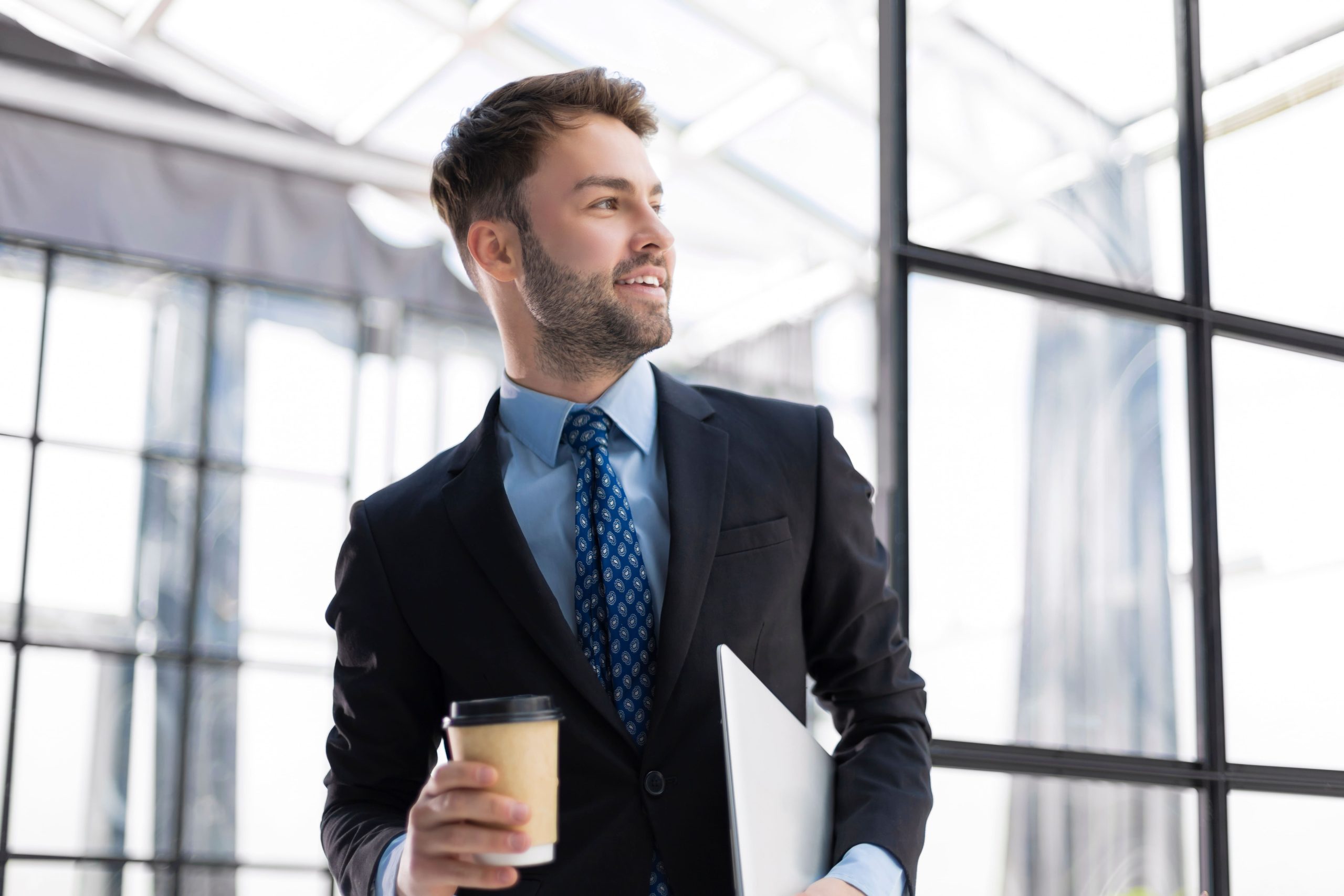 コーヒーカップを持ったスーツを着た男性